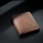 brown leather bifold wallet on black leather textile
